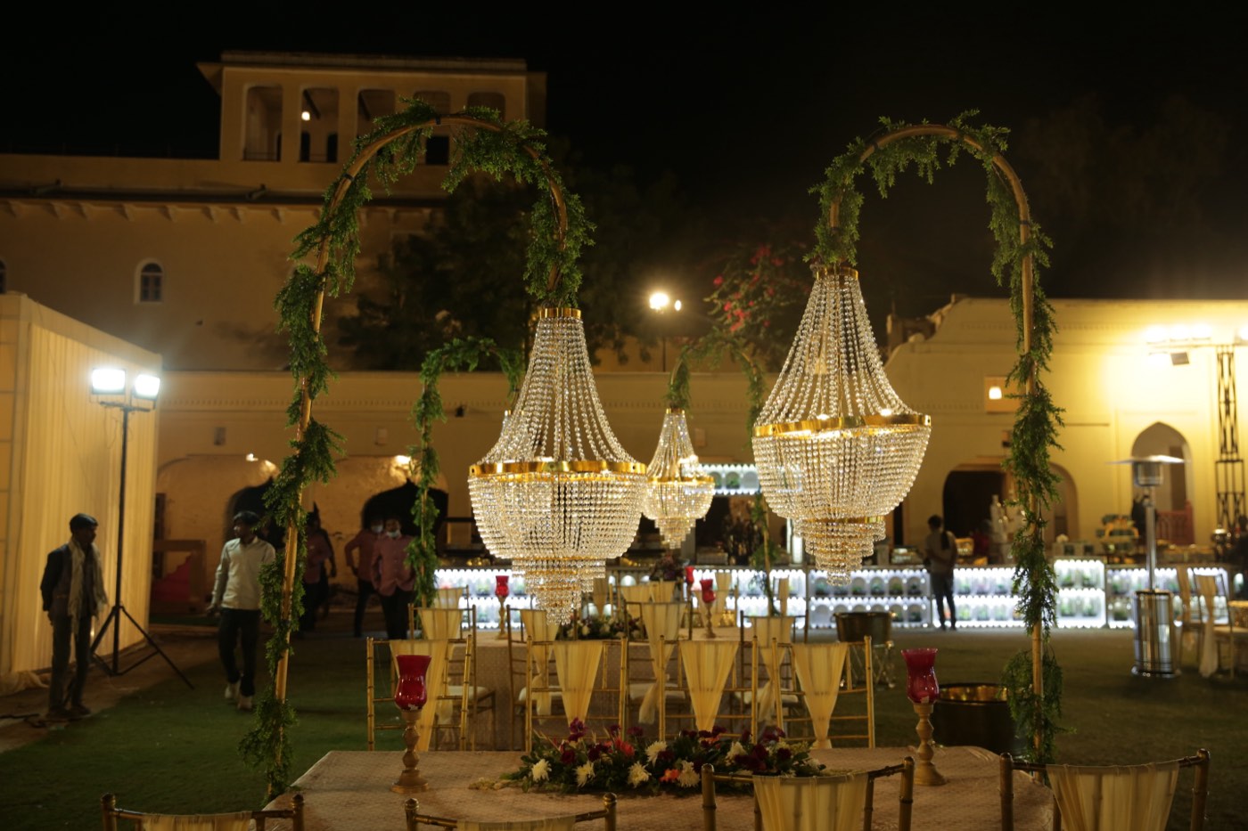 Crystal chandeliers over an outdoor dinner setup