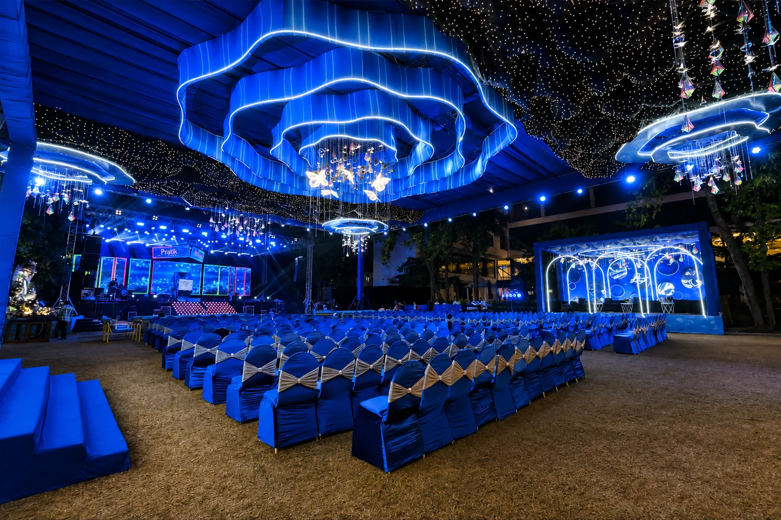 Crystal chandeliers over an outdoor dinner setup